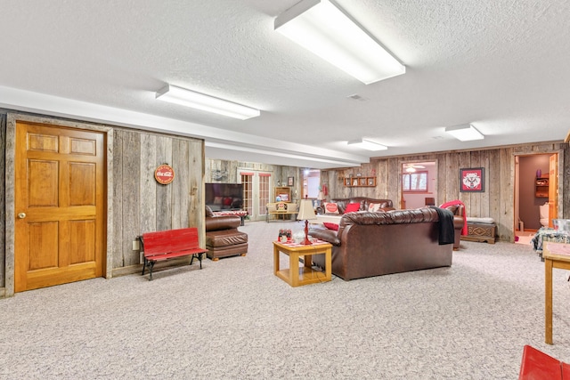 carpeted living room with a textured ceiling and wood walls