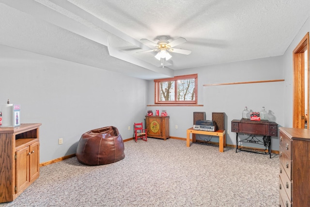 sitting room with ceiling fan, light carpet, and a textured ceiling