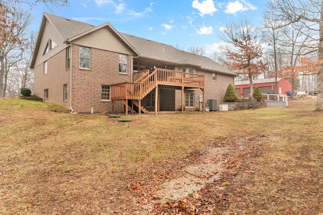 rear view of house featuring central AC unit, a deck, and a lawn