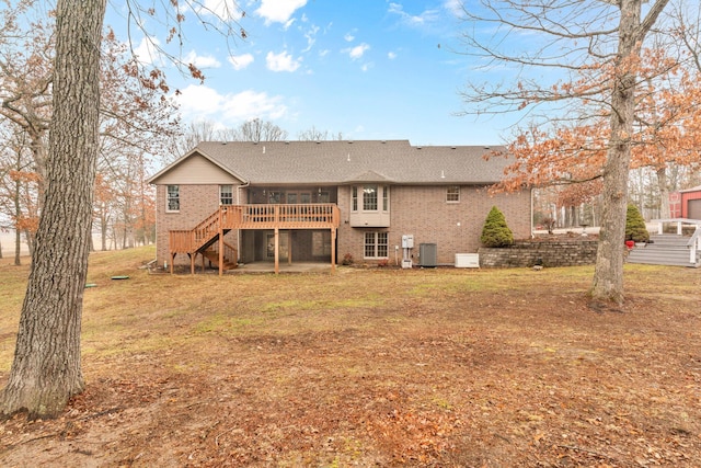 rear view of property with a wooden deck, a yard, and central AC