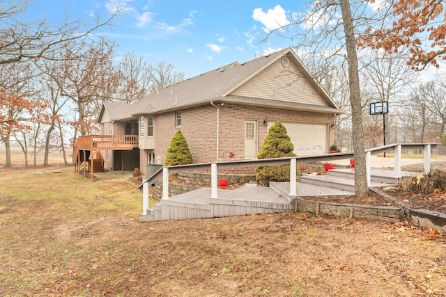 back of property featuring a garage, a yard, and a deck