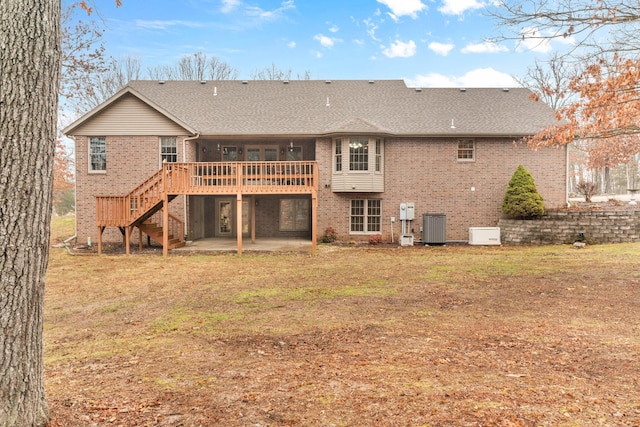 back of house featuring a wooden deck, a lawn, a patio area, and central air condition unit