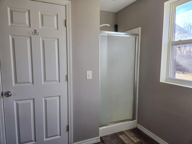 bathroom with wood-type flooring and an enclosed shower