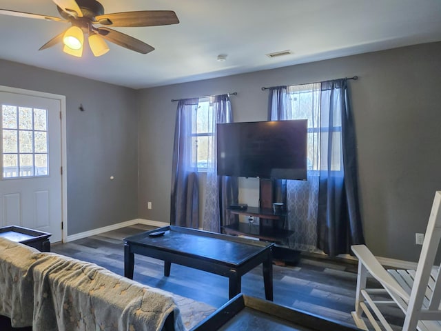 living room featuring dark wood-type flooring and ceiling fan