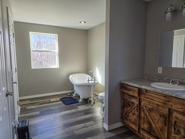 bathroom with vanity, toilet, a bathing tub, and wood-type flooring