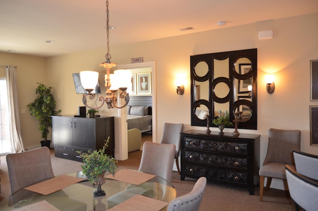 dining room featuring carpet flooring and an inviting chandelier