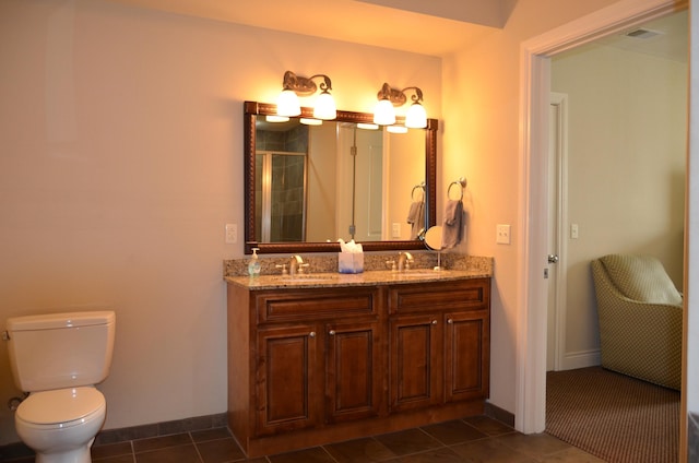 bathroom with vanity, tile patterned flooring, toilet, and walk in shower