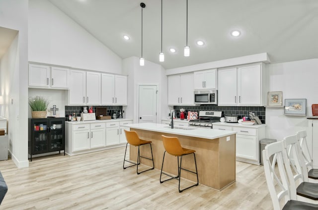 kitchen featuring a sink, appliances with stainless steel finishes, white cabinets, and light countertops