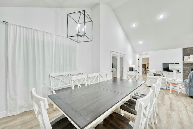 dining room with high vaulted ceiling, light wood-style flooring, recessed lighting, french doors, and a chandelier