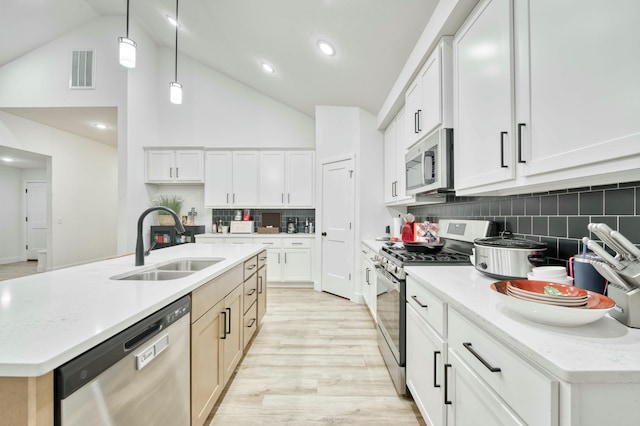 kitchen with visible vents, light wood-style flooring, a sink, appliances with stainless steel finishes, and pendant lighting