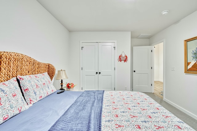 carpeted bedroom with baseboards and a closet