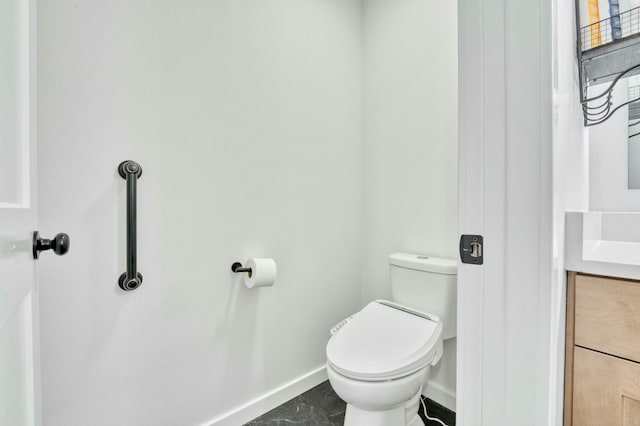 bathroom featuring vanity, toilet, baseboards, and marble finish floor