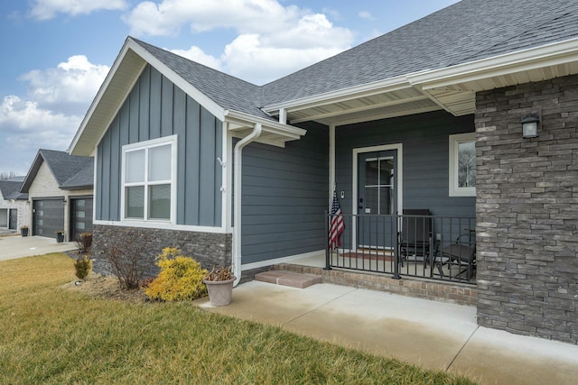 entrance to property with a garage, a lawn, and a porch