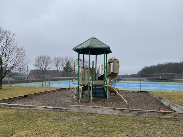 community play area with a tennis court and fence