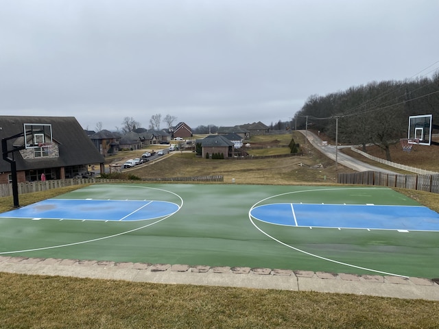 view of basketball court with a residential view, community basketball court, and fence