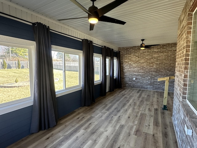 unfurnished sunroom with ceiling fan