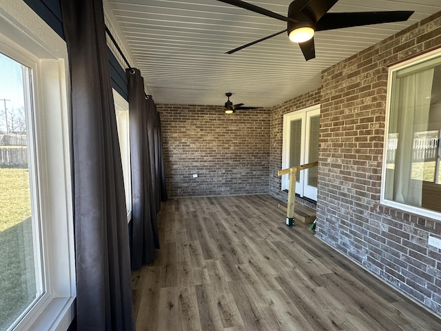 unfurnished sunroom featuring a ceiling fan