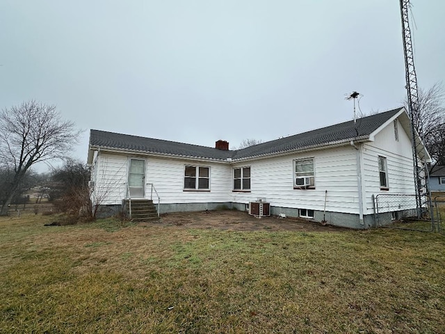 back of property featuring cooling unit and a lawn