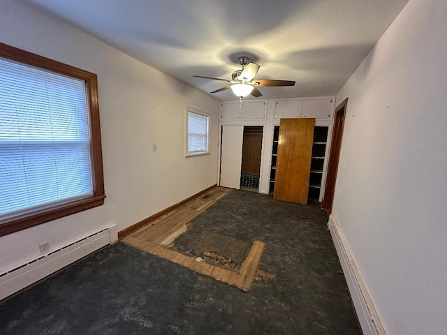 empty room featuring ceiling fan and baseboard heating