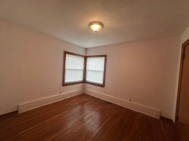 spare room with dark wood-type flooring