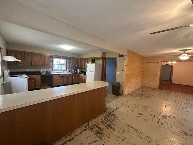 kitchen with sink, white appliances, kitchen peninsula, and ceiling fan