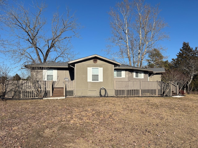 back of property with a yard and a deck