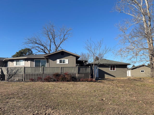 view of front of house with a wooden deck and a front lawn