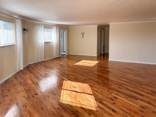 unfurnished room with dark wood-type flooring, ornamental molding, and a textured ceiling