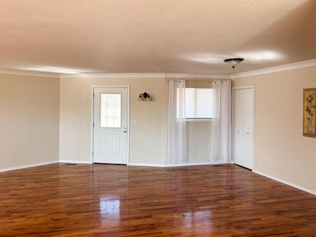 spare room with crown molding, dark hardwood / wood-style flooring, and a textured ceiling