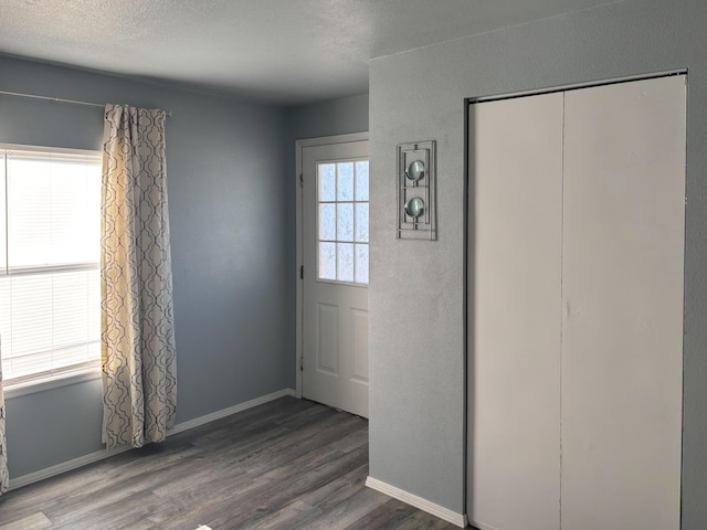 foyer with dark hardwood / wood-style floors and a textured ceiling