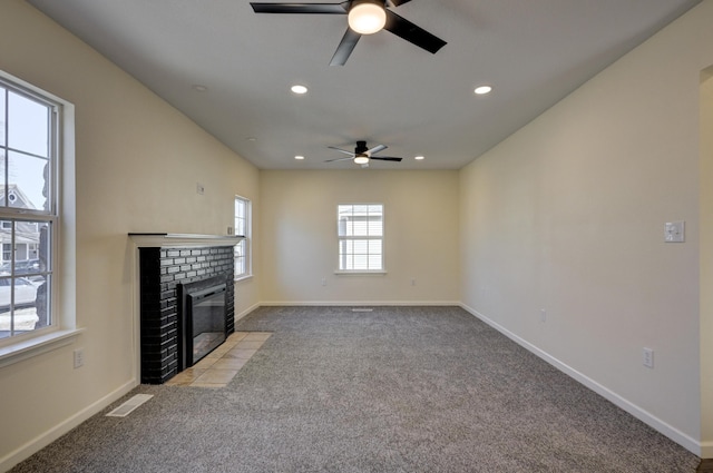 unfurnished living room featuring ceiling fan, light colored carpet, and a fireplace