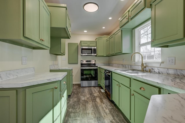 kitchen with dark wood-type flooring, sink, green cabinets, stainless steel appliances, and light stone countertops