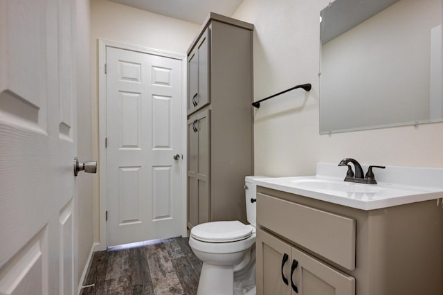 bathroom featuring wood-type flooring, vanity, and toilet