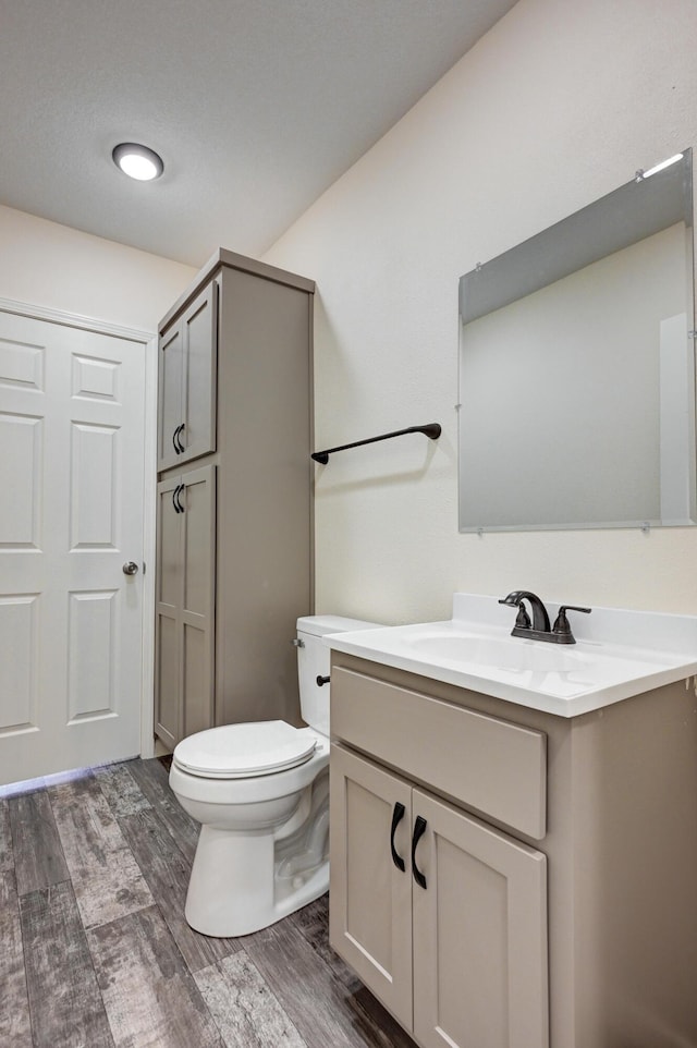 bathroom featuring vanity, toilet, and hardwood / wood-style floors