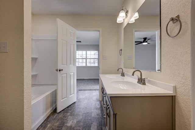 bathroom with vanity, a washtub, and wood-type flooring