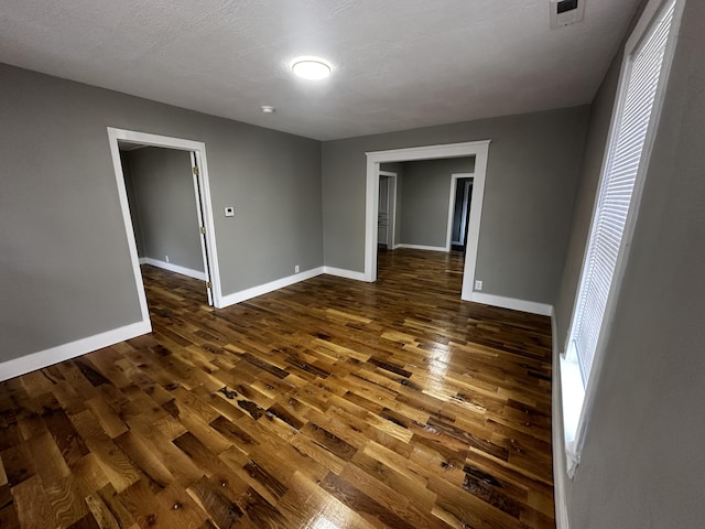 empty room featuring dark hardwood / wood-style floors and a textured ceiling