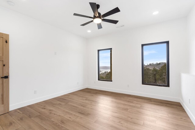 empty room featuring ceiling fan and light hardwood / wood-style flooring