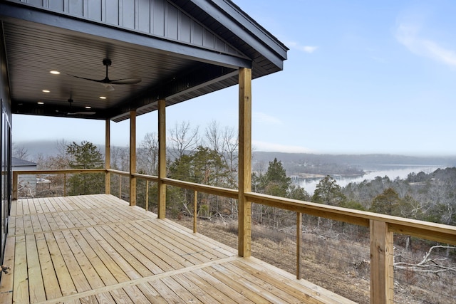 deck with a water view and ceiling fan