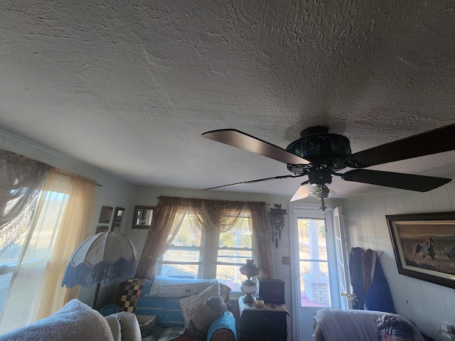 bedroom with ceiling fan and a textured ceiling