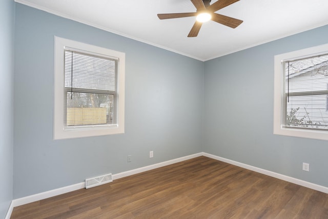 spare room featuring crown molding, plenty of natural light, and dark hardwood / wood-style floors