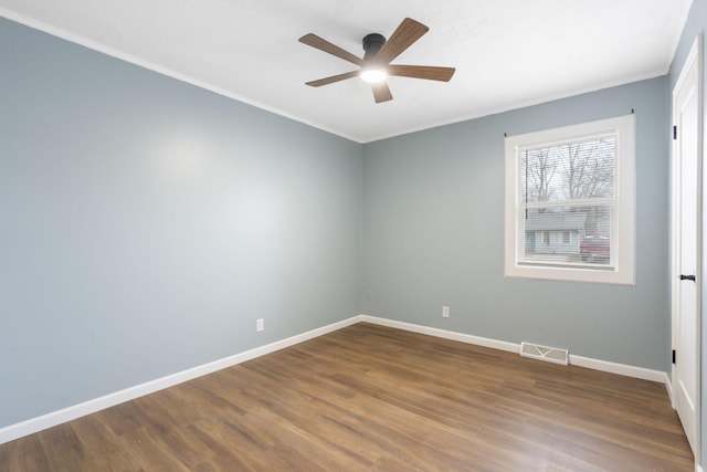 spare room featuring dark hardwood / wood-style flooring, crown molding, and ceiling fan