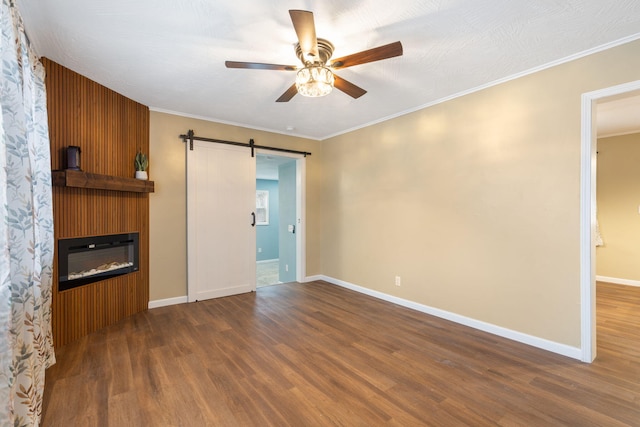 unfurnished living room with crown molding, a barn door, and hardwood / wood-style floors