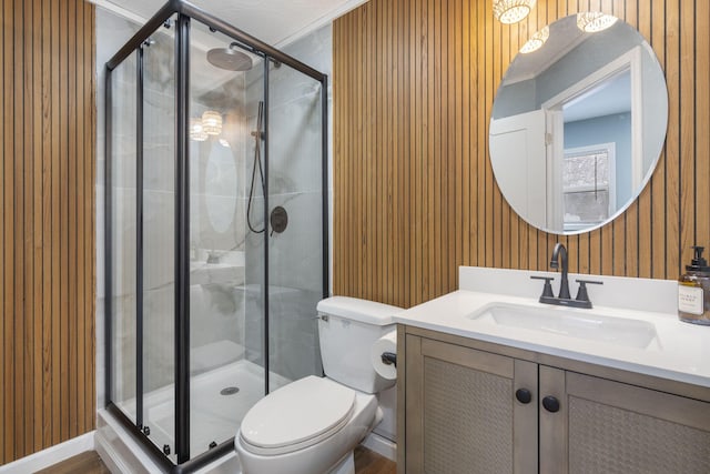 bathroom featuring vanity, a shower with shower door, and toilet