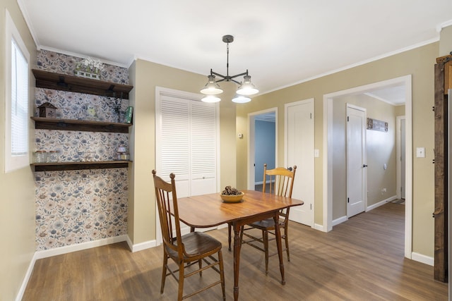 dining area featuring crown molding, dark hardwood / wood-style floors, and a chandelier