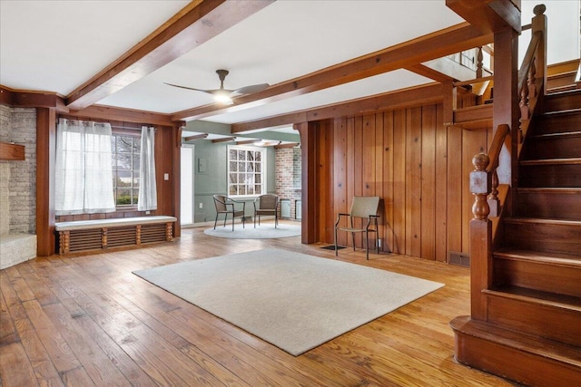 interior space with hardwood / wood-style flooring, wooden walls, and ceiling fan