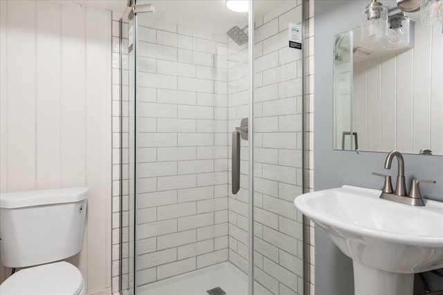 bathroom with walk in shower, sink, and toilet