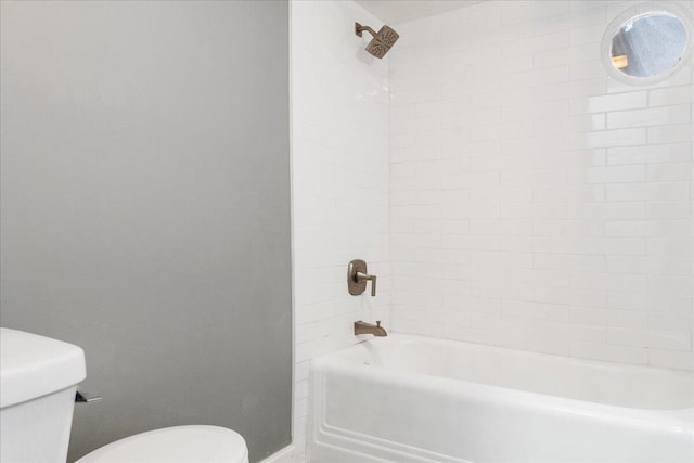 bathroom featuring toilet and tiled shower / bath combo