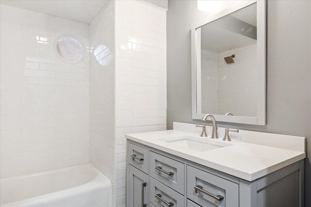 bathroom with tiled shower / bath and vanity