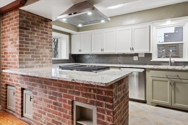 kitchen featuring sink, stainless steel appliances, tasteful backsplash, ventilation hood, and light stone countertops