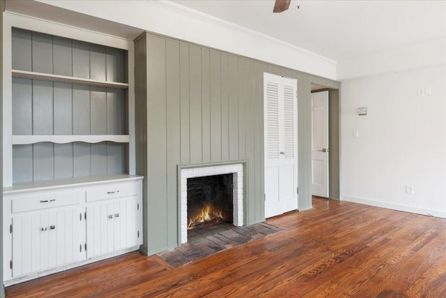 unfurnished living room with ornamental molding, a brick fireplace, dark hardwood / wood-style floors, and ceiling fan